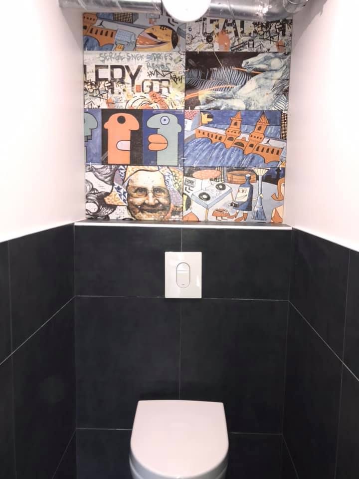 Toilettes : crédence en carreaux illustrés et mur anthracite
